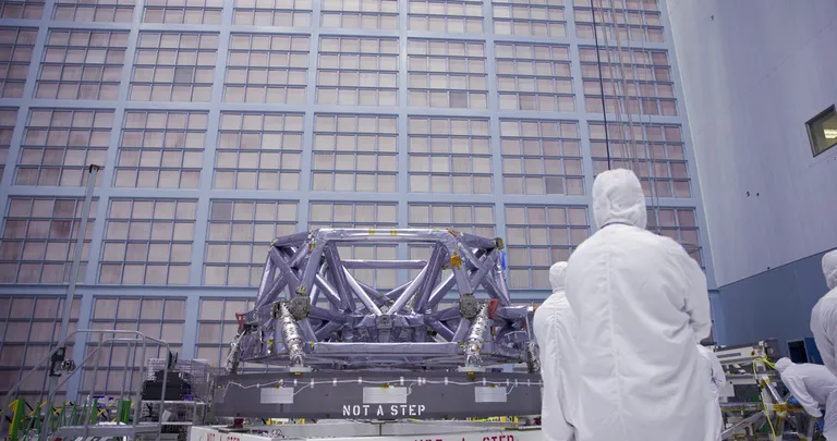 NASA technicians integrate the Roman Space Telescope’s coronagraph instrument into its instrument carrier in a cleanroom.