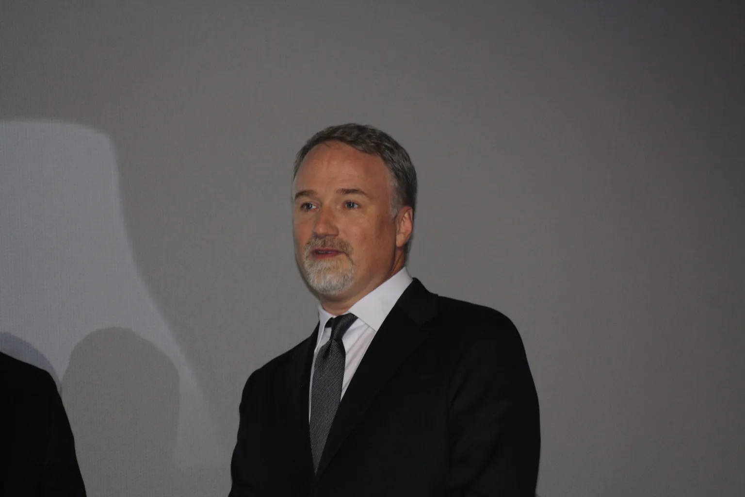 Filmmaker David Fincher in a dark suit at a public event.