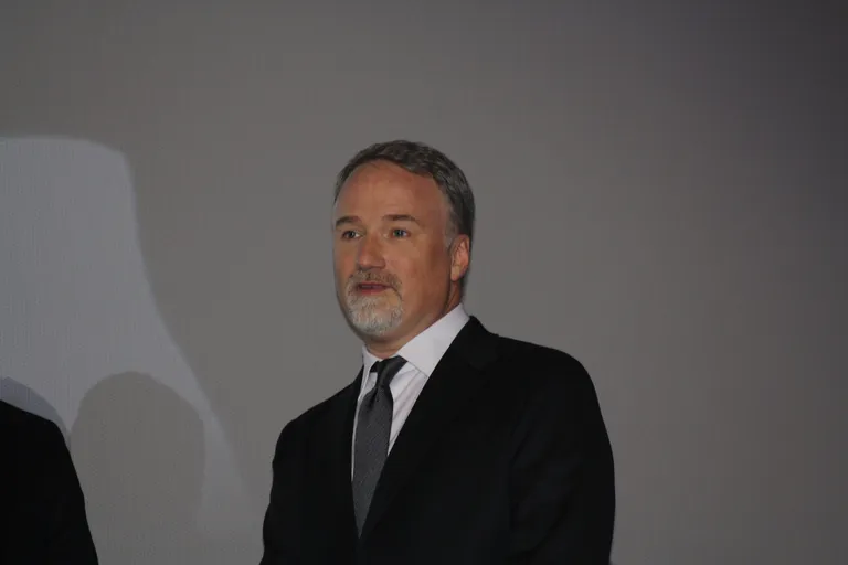Filmmaker David Fincher in a dark suit at a public event.